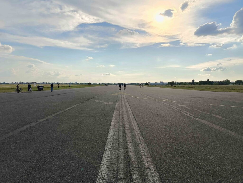 Il vasto orizzonte dell'ex-aeroporto di Tempelhof, in un giorno di sole rigato da qualche nuvola, visto dall'asfalto della vecchia pista.